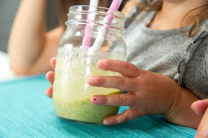 immune boosting snack of child drinking a green smoothie