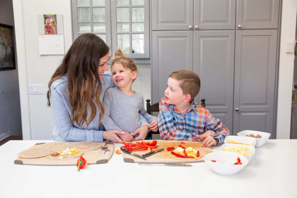 Mom with two children, smiling while preparing school lunches together