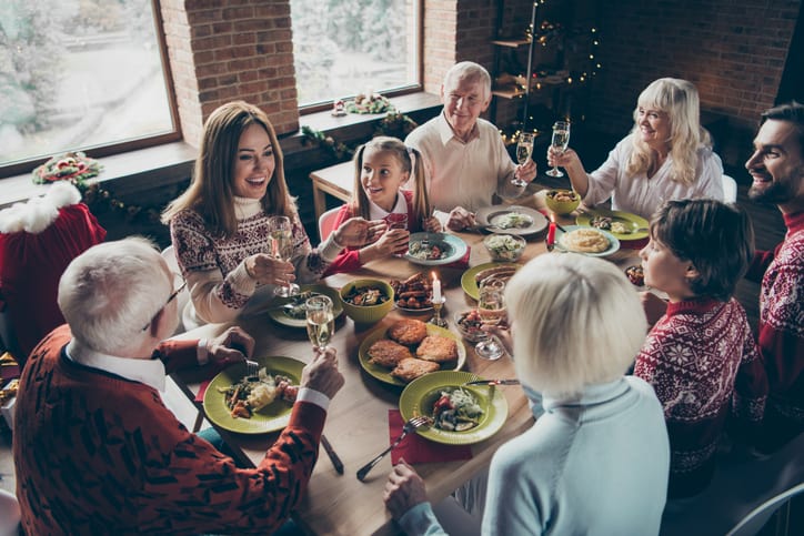 family sitting around a dinner table enjoying a holiday feast