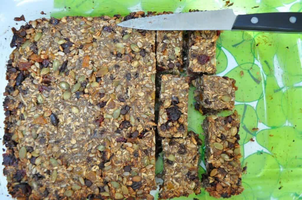 granola bar mix spread out on a pan, ready to cut into rectangles