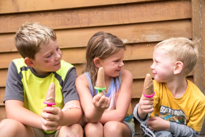 kids sitting in a group holding up popsicles