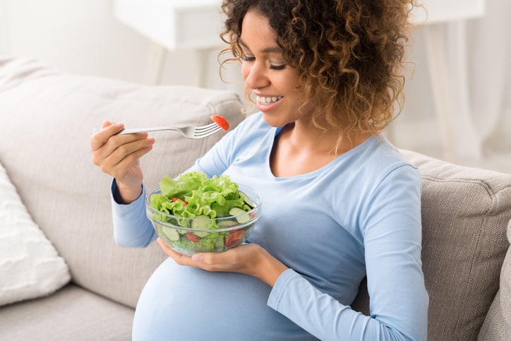 pregnant woman eating vegetable salad