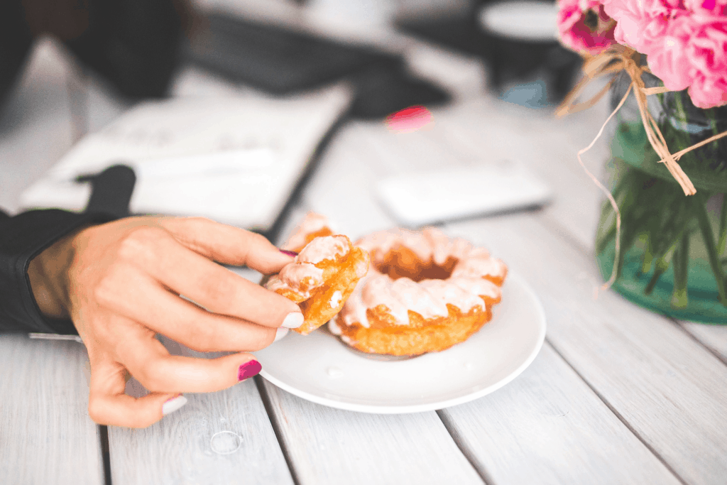 woman eating donut to satisfy pregnancy cravings