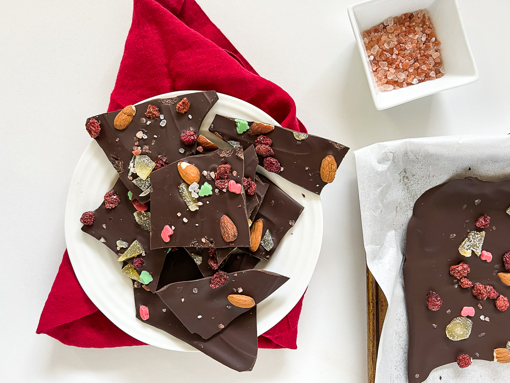 dark chocolate bark with sea salt and nuts and dried fruit on a plate