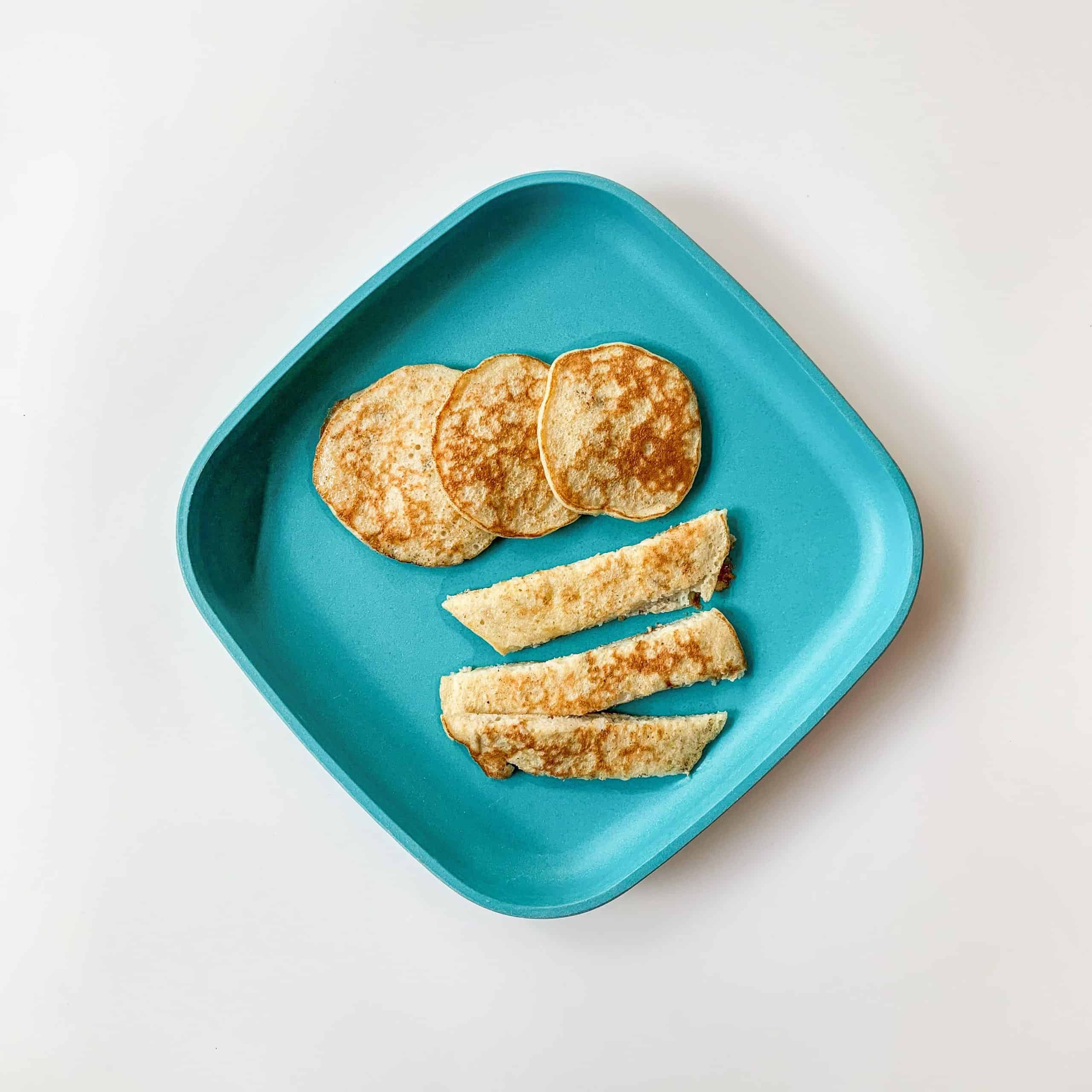 Banana pancakes cut into strips on a blue plate