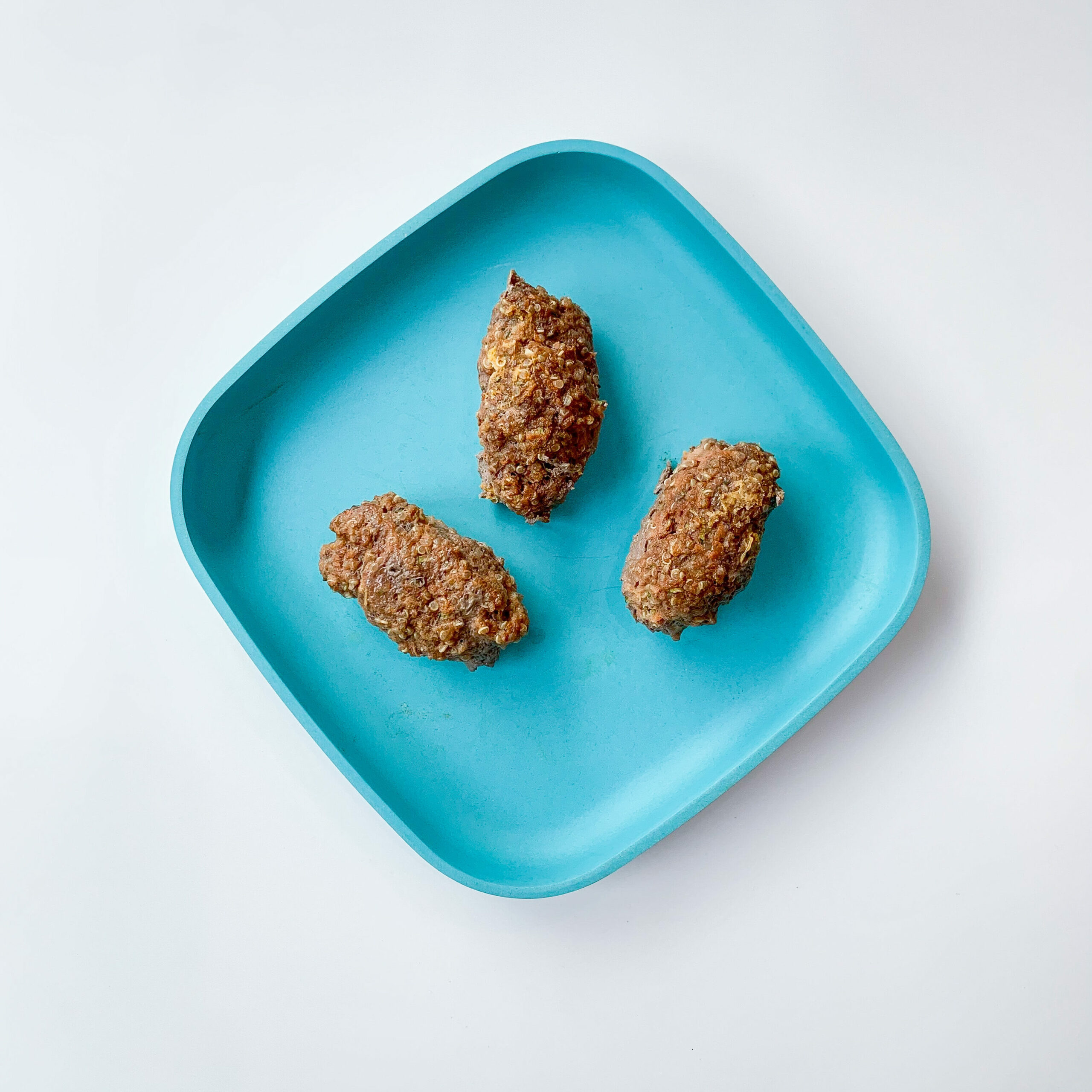 top view of quinoa meatballs on a blue plate