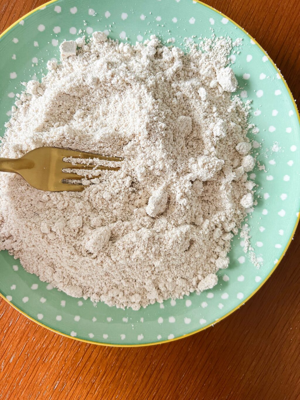 ground oat flour on a plate with a fork mixing it up