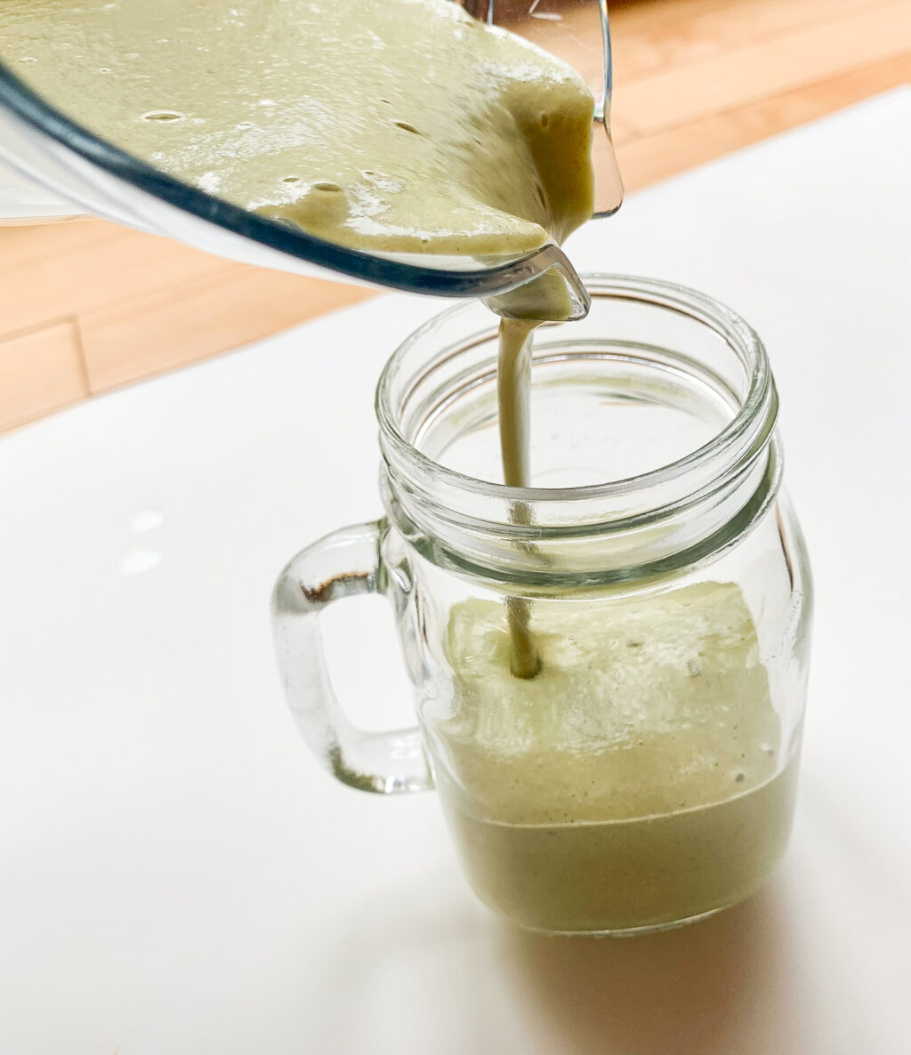 smoothie being poured into a glass mason jar