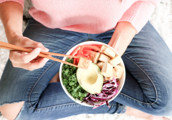 top down view of a person holding a salad bowl on her lap