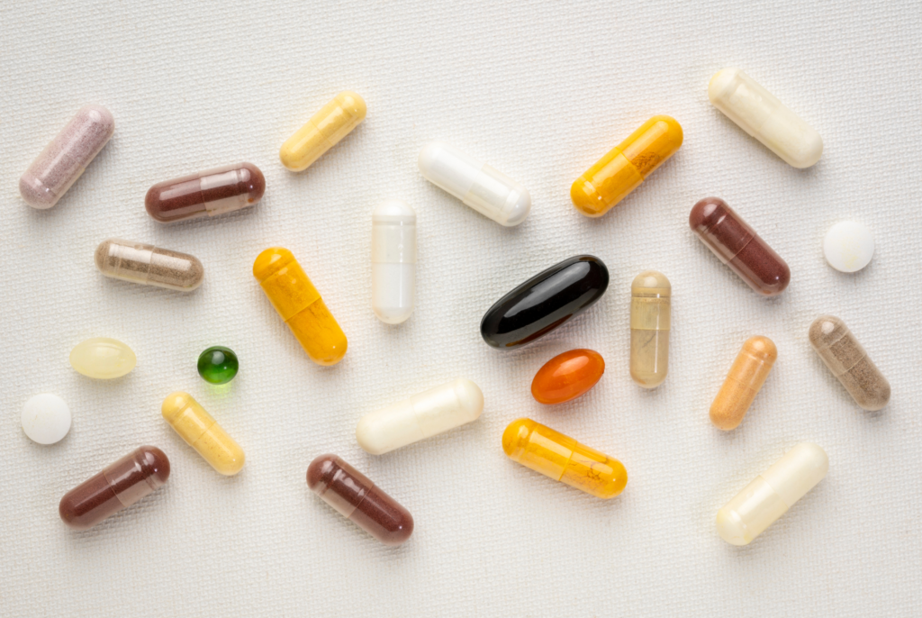 top down view of a variety of vitamin pills on a white surface