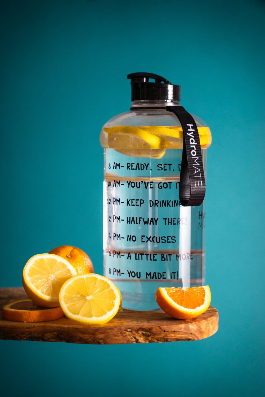 Fechar de uma garrafa de água com fatias de água e limão