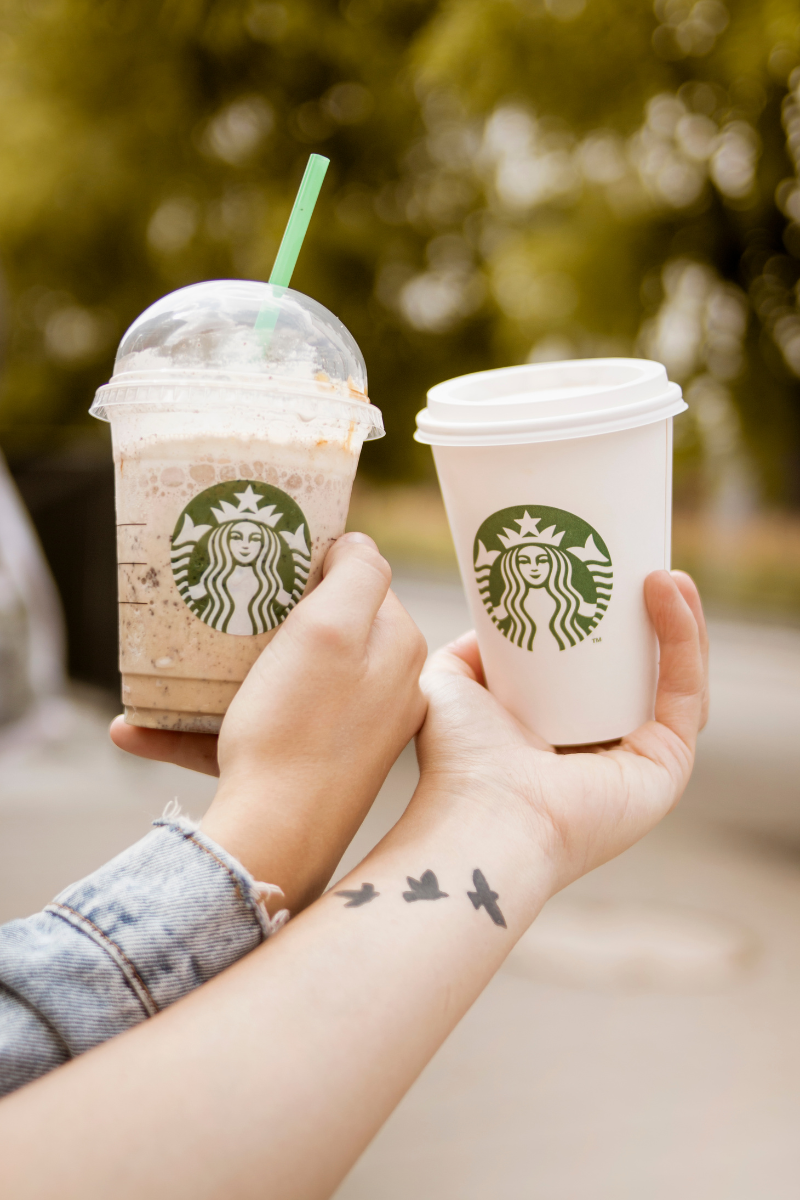 two hands holding Starbucks drinks side by side