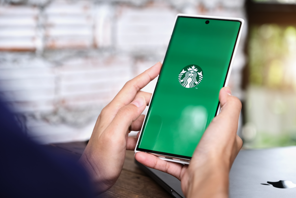 a person holding a phone with Starbucks app