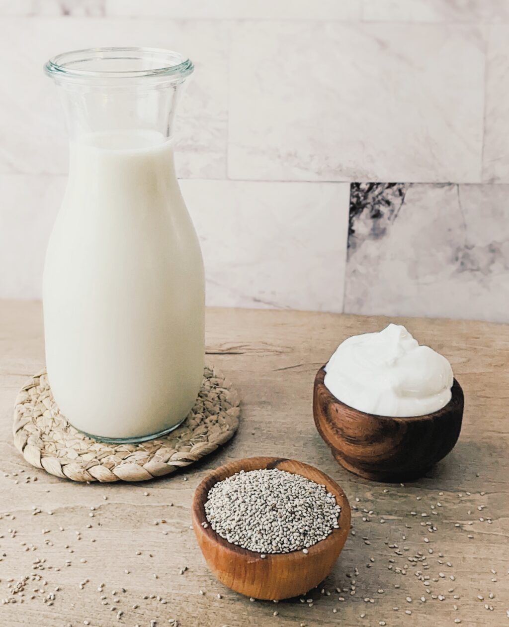 close up of ingredients needed to make chia pudding including milk, yogurt and chia seeds
