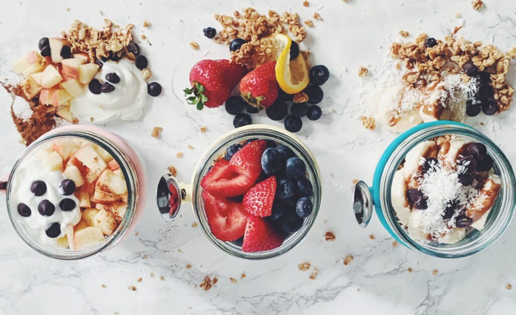 top down view of chia pudding in mason jars topped with fruits and granola