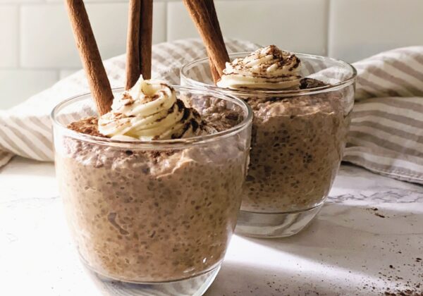 side view of pumpkin pie chia pudding in glass mugs with cinnamon sticks