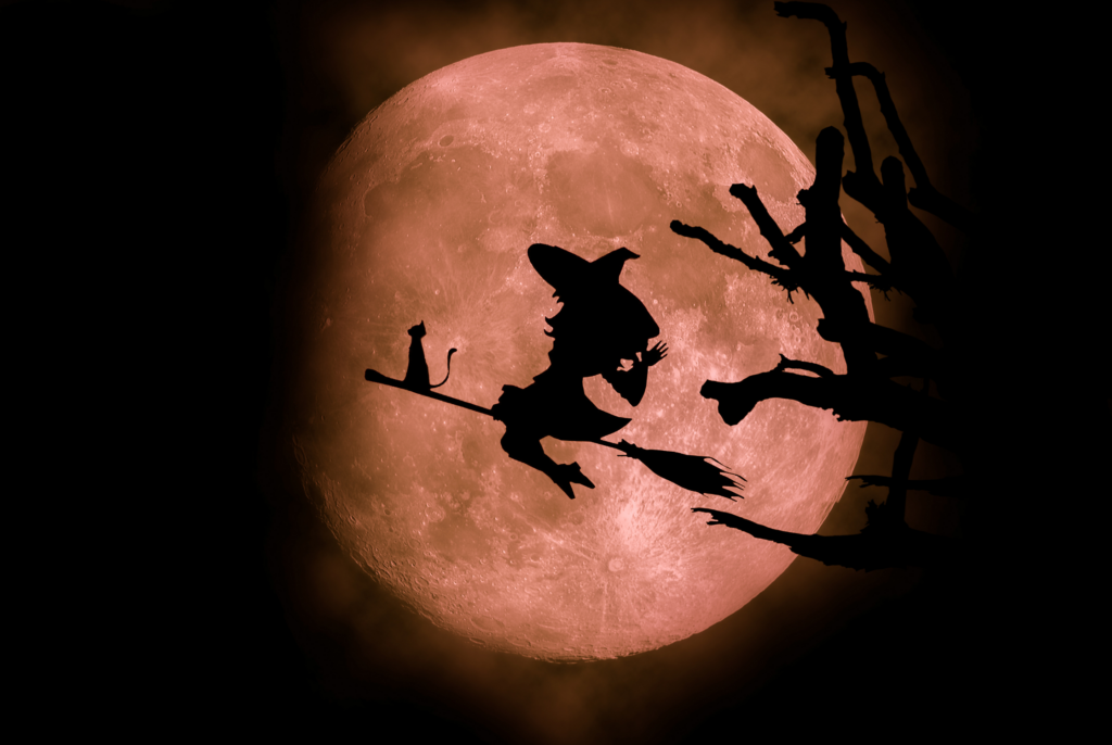 a silhouette of a witch flying in the sky