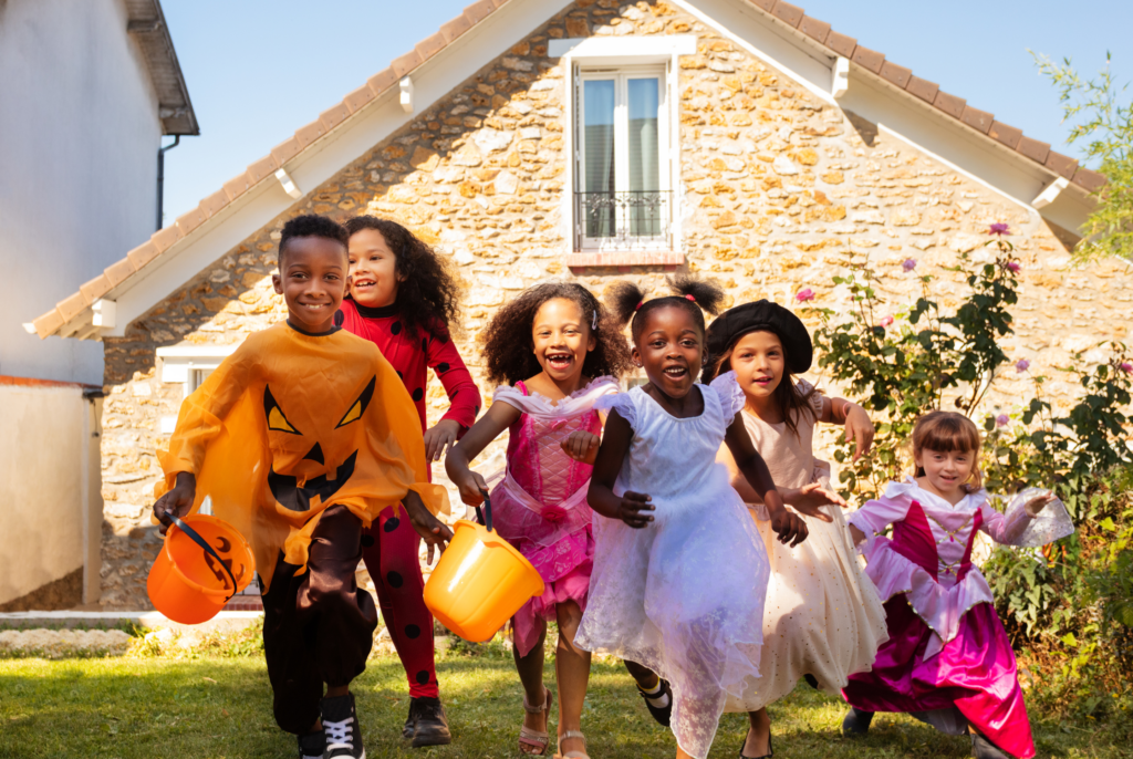 kids dressed up for Halloween running towards the camera with smiling faces