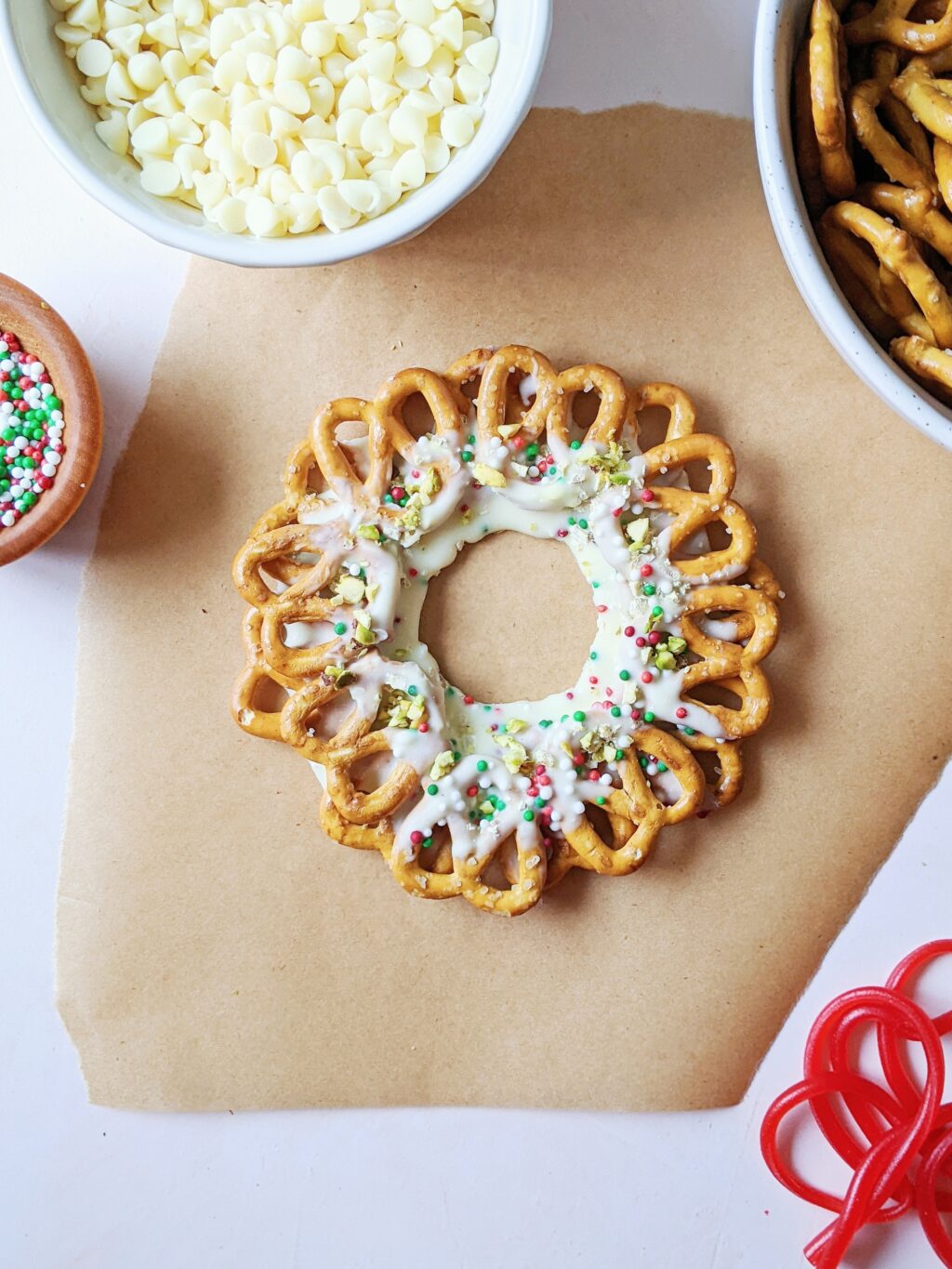 top down view of pretzel wreaths topped with pistachios and coloured sprinkles