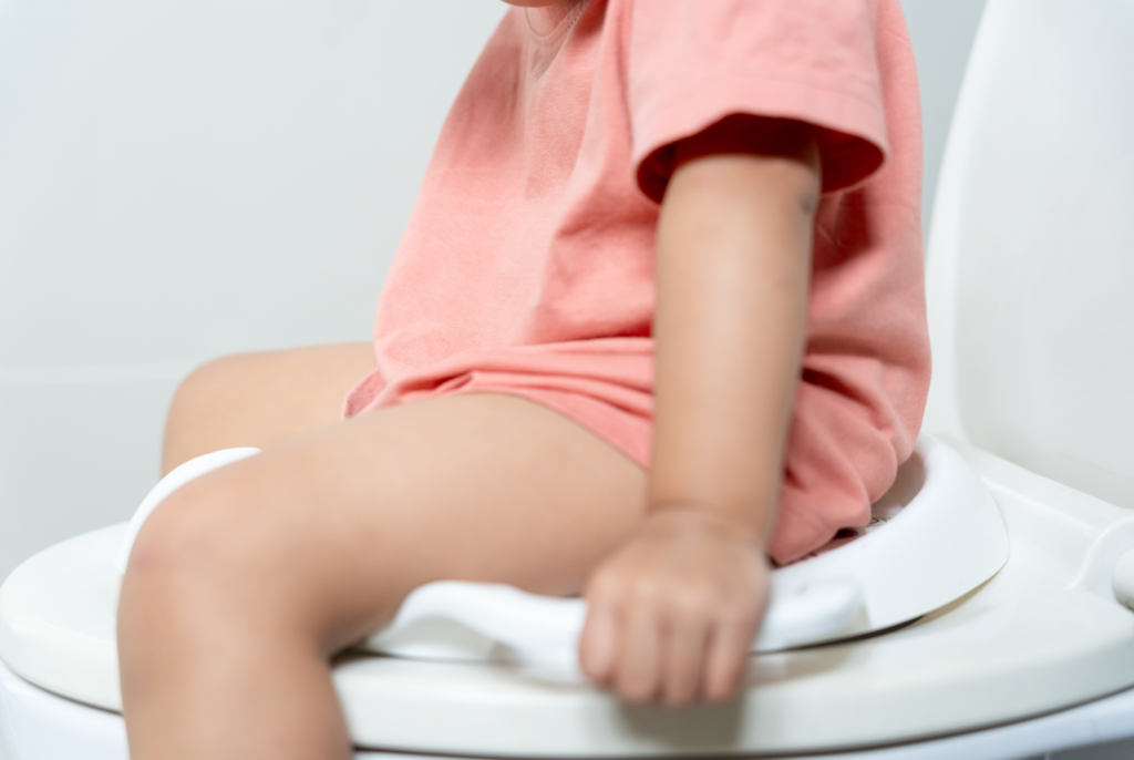 close up of a toddler sitting on the toilet