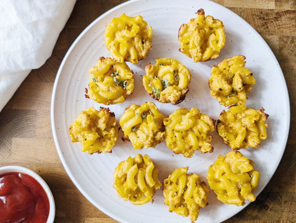 close up of mac and cheese bites on a plate with a side of ketchup