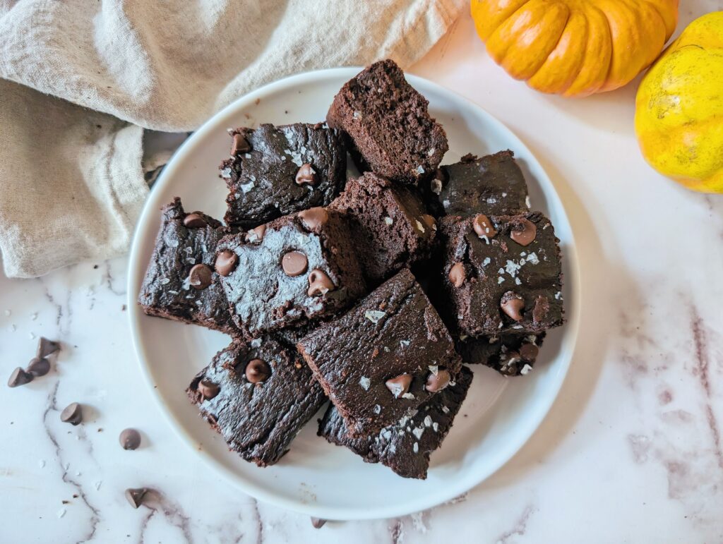 top down view of gluten-free pumpkin brownies on a plate sprinkled with flaky salt