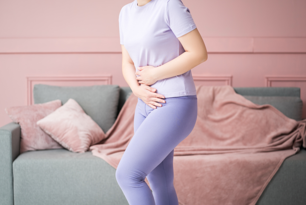 close up of a constipated women in perimenopause, holding her stomach