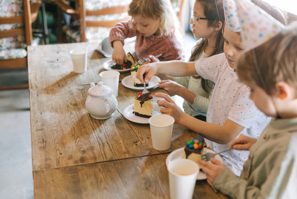 a group of kids eating cake together for a birthday party